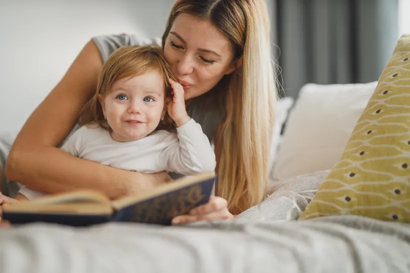 Küçük bir çocukla kitap okuyan bakıcı